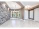 Open-concept dining room features a stone accent wall, tile flooring, tray ceiling, and access to other living spaces at 4915 Old Tree Pl, Sarasota, FL 34233