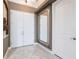 Elegant foyer with tiled floor, large mirror, and white doors at 4915 Old Tree Pl, Sarasota, FL 34233