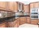 Gourmet kitchen with custom wood cabinets, granite countertops, stainless steel appliances, and designer backsplash at 4915 Old Tree Pl, Sarasota, FL 34233