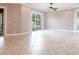 Large living room featuring tile flooring, sliding glass doors to a beautiful outdoor pool area and a ceiling fan at 4915 Old Tree Pl, Sarasota, FL 34233