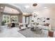 Bright, open-concept living room featuring elegant chandelier, tray ceiling, neutral tones and dining area with great natural light at 4915 Old Tree Pl, Sarasota, FL 34233