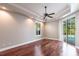 Bright main bedroom featuring an ensuite, hardwood floors, a ceiling fan and a sliding glass door with access to the pool at 4915 Old Tree Pl, Sarasota, FL 34233