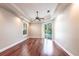 Spacious main bedroom featuring tray ceiling, wood floors, and sliding glass doors to the pool at 4915 Old Tree Pl, Sarasota, FL 34233