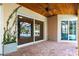 A covered outdoor patio with brick pavers and a view of a pool in a screened enclosure at 4915 Old Tree Pl, Sarasota, FL 34233