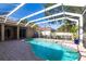 Relaxing screened-in pool with brick paver deck and a view of the backyard at 4915 Old Tree Pl, Sarasota, FL 34233