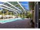 Screened-in pool area featuring a brick deck, plants, and trees at 4915 Old Tree Pl, Sarasota, FL 34233