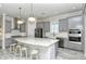 Modern kitchen with gray cabinets, stainless steel appliances, and a large island at 5376 Trails Bend Ct, Sarasota, FL 34238