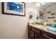 Stylish powder room featuring a granite countertop, wood vanity, and decorative accents at 5522 Cartagena Dr, Sarasota, FL 34233