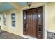 Inviting front entry with a dark wood door, sidelights, and a covered porch at 5522 Cartagena Dr, Sarasota, FL 34233