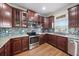 Bright kitchen with stainless steel appliances, granite countertops, mosaic backsplash, and wood cabinets at 5522 Cartagena Dr, Sarasota, FL 34233