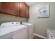 The laundry room features a Whirlpool washer and dryer with overhead cabinets and laminate flooring at 5522 Cartagena Dr, Sarasota, FL 34233