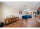 Open-concept living area with wood floors, view of kitchen, blue sectional, and decorative wall accents at 5522 Cartagena Dr, Sarasota, FL 34233