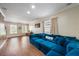 Bright living room featuring a comfortable blue sectional couch, wood-style flooring, and ample natural light at 5522 Cartagena Dr, Sarasota, FL 34233