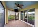 Screened-in porch featuring a brick floor, a ceiling fan, and glass sliding doors at 5522 Cartagena Dr, Sarasota, FL 34233