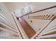 Top-down view of a staircase showcases wood floors, white railings, and a bright, open entryway at 5522 Cartagena Dr, Sarasota, FL 34233