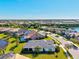 Aerial view of a neighborhood with lush greenery, waterfront properties, and luxurious single-story homes at 5590 Rain Lily Ct, Sarasota, FL 34238