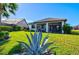Lush backyard featuring a covered patio, tropical landscaping, and views of neighboring homes at 5590 Rain Lily Ct, Sarasota, FL 34238