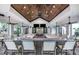 Stylish bar area with ample seating, granite countertops, ceiling fans, and a wood-paneled ceiling at 5590 Rain Lily Ct, Sarasota, FL 34238