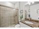 Bathroom features tiled walk-in shower, decorative mirror, granite countertop, and a vessel sink at 5590 Rain Lily Ct, Sarasota, FL 34238