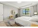 Bright bedroom featuring neutral walls, natural light, tray ceilings, and serene water views at 5590 Rain Lily Ct, Sarasota, FL 34238