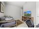 The bedroom includes a daybed, entertainment center with TV, and a view of a tropical scene at 5590 Rain Lily Ct, Sarasota, FL 34238