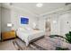Well-lit bedroom featuring neutral paint, tray ceilings, ensuite bathroom, and a plush area rug at 5590 Rain Lily Ct, Sarasota, FL 34238