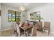 Bright dining room with modern chandelier and views of the lake at 5590 Rain Lily Ct, Sarasota, FL 34238