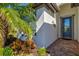 Inviting entryway with a decorative glass door, brick pavers, and lush tropical landscaping at 5590 Rain Lily Ct, Sarasota, FL 34238