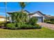 Landscaped single-story home featuring lush landscaping, and a brick driveway at 5590 Rain Lily Ct, Sarasota, FL 34238
