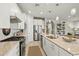 Contemporary kitchen with an island, stainless steel appliances, white cabinets, and a view into the living room at 5590 Rain Lily Ct, Sarasota, FL 34238