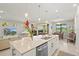 Open-concept kitchen with an island, stainless steel appliances, and view of the lanai at 5590 Rain Lily Ct, Sarasota, FL 34238