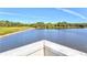 View from a wooden dock over a serene lake with lush green shorelines and clear sky at 5590 Rain Lily Ct, Sarasota, FL 34238