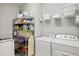 This laundry room features modern appliances, ample storage, and well-organized shelving for convenience at 5590 Rain Lily Ct, Sarasota, FL 34238