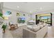 Bright, open living room with sliding glass doors to patio and white baby grand piano at 5590 Rain Lily Ct, Sarasota, FL 34238