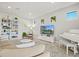 Neutral living room features a piano, TV, and view of the lake at 5590 Rain Lily Ct, Sarasota, FL 34238
