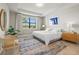 Serene main bedroom with tray ceiling, large window overlooking the lake, and neutral décor at 5590 Rain Lily Ct, Sarasota, FL 34238