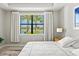 Well lit main bedroom showing view of lake and palm trees at 5590 Rain Lily Ct, Sarasota, FL 34238
