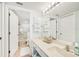 Bright bathroom featuring a long vanity with double towel racks, coastal decor, and tile flooring at 5647 Sheffield Greene Cir # 29, Sarasota, FL 34235