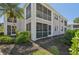 Exterior view of the condo featuring a private screened-in balcony with lush landscaping at 5647 Sheffield Greene Cir # 29, Sarasota, FL 34235