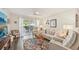 Bright living room with a ceiling fan, patio access, and comfortable furnishings at 5647 Sheffield Greene Cir # 29, Sarasota, FL 34235