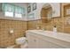 Well-lit bathroom with a white marble vanity and earth-toned tiled walls at 568 Sheridan Dr, Venice, FL 34293