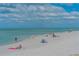 Scenic beach view with people relaxing, enjoying the sun, and walking along the shore on a sunny day at 568 Sheridan Dr, Venice, FL 34293