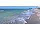 Inviting beach scene with gentle waves and soft sand, perfect for a relaxing day by the ocean at 568 Sheridan Dr, Venice, FL 34293
