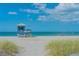 A lifeguard tower stands watch over a serene beach with blue skies and turquoise water at 568 Sheridan Dr, Venice, FL 34293
