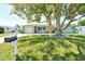 Single-story home featuring a well-manicured lawn and mature landscaping, complemented by a yellow front door at 568 Sheridan Dr, Venice, FL 34293
