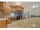 Kitchen area featuring wood cabinets, granite countertops, and stainless steel appliances at 568 Sheridan Dr, Venice, FL 34293