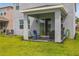 Cozy back patio with seating, barbecue and well-maintained lawn offers a relaxing outdoor space at 5759 Bungalow Grove Ct, Palmetto, FL 34221