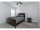 This bedroom features neutral carpeting, a dark wood bed frame, and a window for natural light at 5759 Bungalow Grove Ct, Palmetto, FL 34221
