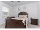 Charming bedroom with a dark wood bed frame, soft neutral carpet, and natural light from the window at 5759 Bungalow Grove Ct, Palmetto, FL 34221
