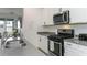 Kitchen featuring stainless steel appliances, white cabinetry, and a view to the backyard through sliding glass doors at 5759 Bungalow Grove Ct, Palmetto, FL 34221